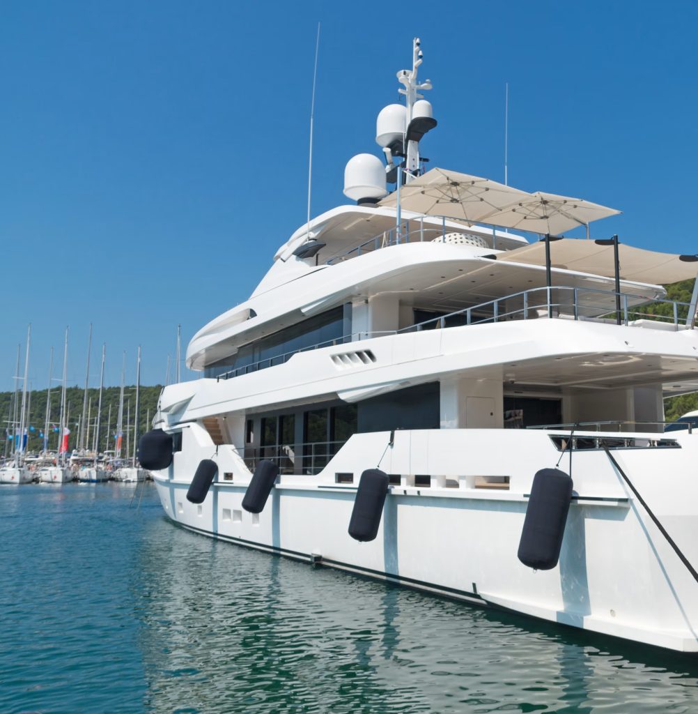 Luxury yacht docked at a marina on a sunny day.